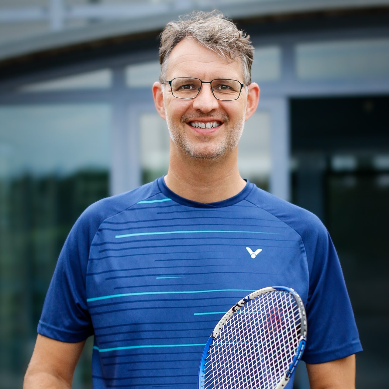 Peter Seitz Auf diesem Bild ist der aktuelle Abteilungsleiter Peter Seitz abgebildet. Peter hat schwarzgraue Haare und trägt eine Brille. Er hat ein blaues Trikot an und ist vor einem schwarzen Hintergrund abgebildet.